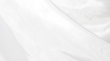 Yumuşak ışığı yansıtan parlak beyaz ipek kumaş, zengin bir doku yaratır.