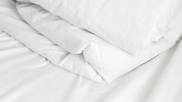 Fresh white bedding neatly folded on bed for premium hotel comfort and rest.
