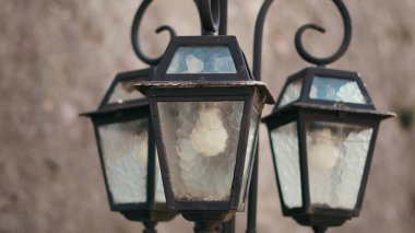 Açık hava antika feneri büyüleyici bir akşam sokağında sıcak ışık sağlıyor.