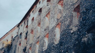 Yıpranmış yüzeyi ve dokuları olan eski bir ortaçağ kalesinin eski taş duvarı.