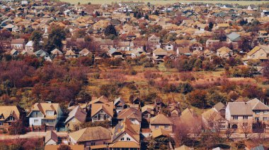 Zakarpattia 'daki Mukachevo şehrinin sonbahar renklerinde çatıları ve ağaçları ile sonbahar manzarası