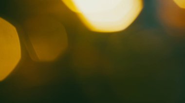 Yumuşak altın parıltı ve kahverengi renk paleti ile sinematik bokeh arkaplan.