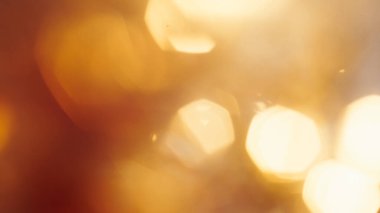 Yumuşak altın parıltı ve kahverengi renk paleti ile sinematik bokeh arkaplan.