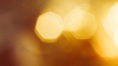 Yumuşak altın parıltı ve kahverengi renk paleti ile sinematik bokeh arkaplan.