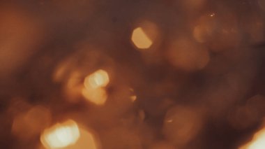 Yumuşak altın parıltı ve kahverengi renk paleti ile sinematik bokeh arkaplan.
