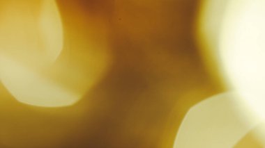 Altın sarısı kahverengi tonlarda soyut bokeh ile yumuşak sinematik arkaplan.