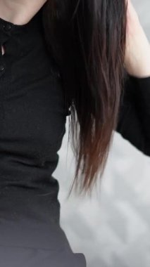 Uzun esmer saçlar, kuaförde saç kurutma makinesiyle kurutuluyor.