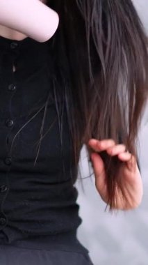 Uzun esmer saçlar, kuaförde saç kurutma makinesiyle kurutuluyor.