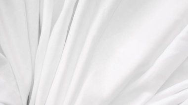 Düz kumaşlı ve modern modda huzurlu beyaz bir yatak örtüsü.