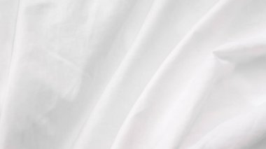 Düz kumaşlı ve modern modda huzurlu beyaz bir yatak örtüsü.