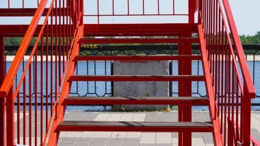Temiz mimari tarzına sahip cesur şehir arkaplanı olarak kırmızı boyanmış çelik merdivenler.