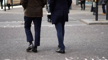 Şehir ortamında isimsiz bir kalabalık yürüyor..