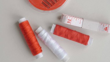DIY için iplikler, iğneler ve mezura da dahil olmak üzere düz dikiş araçları yatar.