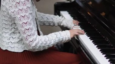 Sokak performansı sırasında zarif elbiseli bir kadın piyano çalıyor.