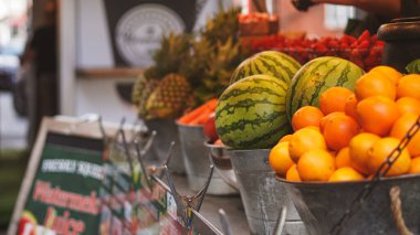 Yerel markette taze meyve suyu ve olgun ürünlerle açık hava meyve tezgahı.