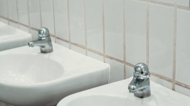 El yıkama için birden fazla lavabosu olan hijyenik beyaz tuvalet.