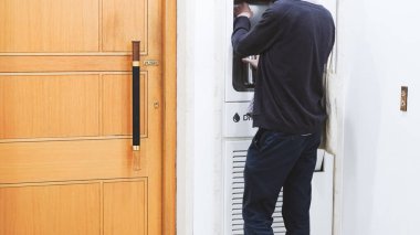 Klasik bir iç mekanda içmek için eski tarz su soğutucusu kullanan biri.