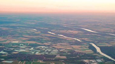 Yumuşak tepeleri ve alacakaranlıkta parlayan yaz gökyüzünün insansız hava aracı görüntüsü..