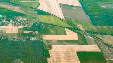 Yaz günbatımının altın ışığı yukarıdan görünen engin kırsal araziye düşüyor..