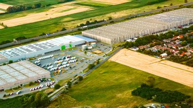 Gün batımının altında park etmiş kamyonlarla sanayi manzarası.