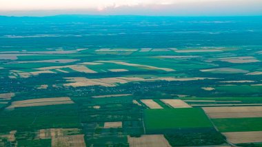 Yaz günbatımının altın ışığı yukarıdan görünen engin kırsal araziye düşüyor..