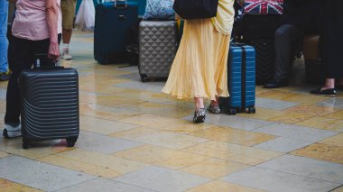 Tren peronunda yürüyen bacaklar ve bavullar aracılığıyla yeniden yerleştirme kavramı