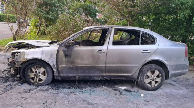 Yanan gri araba ciddi bir yangın kazasından sonra gün ışığında hasar gördü. Yüksek kalite fotoğraf