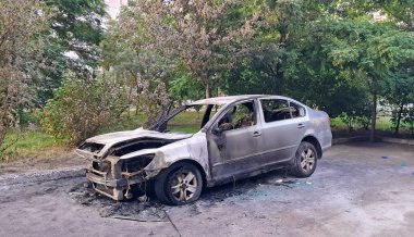 Yanan gri araba ciddi bir yangın kazasından sonra gün ışığında hasar gördü. Yüksek kalite fotoğraf