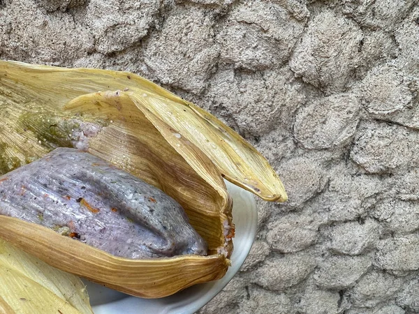メキシコのオアハカにあるトウモロコシの殻に包まれた青いトウモロコシとカボチャの花で作られたタマーレ — ストック写真