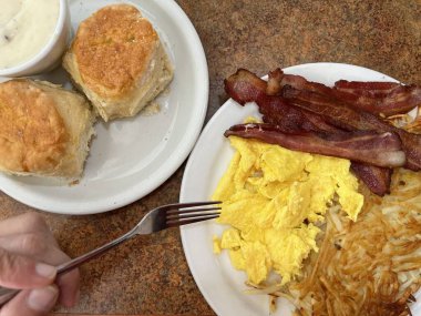 Kaliforniya 'da bir lokantada geleneksel Amerikan kahvaltısı. Pastırma, yumurta, patates, bisküvi ve sos.. 