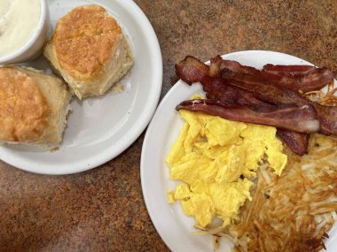 Kaliforniya 'da bir lokantada geleneksel Amerikan kahvaltısı. Pastırma, yumurta, patates, bisküvi ve sos.. 