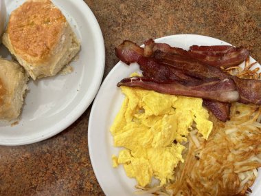 Kaliforniya 'da bir lokantada geleneksel Amerikan kahvaltısı. Pastırma, yumurta, patates, bisküvi ve sos.. 