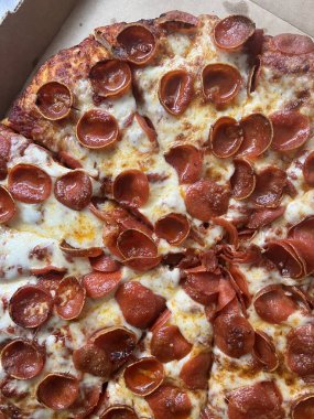 Mukavva kutunun üzerinde büyük boy pepperoni pizza..