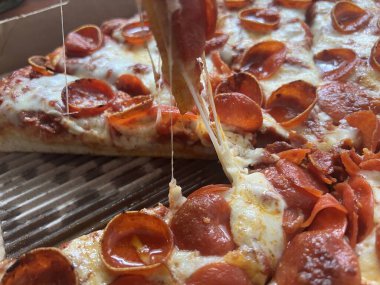 Karton bir kutuda peynirli ve pepperonili pizza..