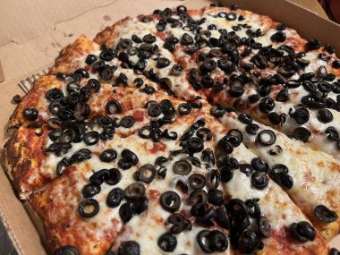 Ekstra peynirli ve kalın kenarlı siyah zeytinli vejetaryen pizzası.