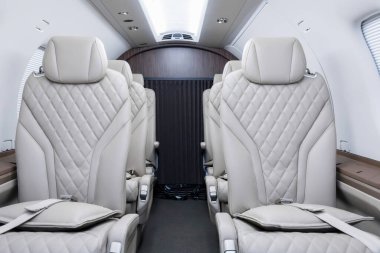 Modern bir iş turboprop uçağı, açık deri koltuklar ve düşük kolluklar..