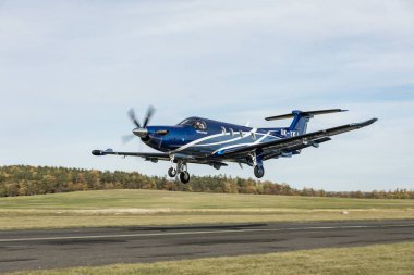 PRIBRAM, CZECH Cumhuriyet - 9 Kasım 2023. Lüks, modern bir Pilatus PC-12 NG uçağı güneşli bir günde özel bir havaalanından havalanır. PC-12 NG turboprop uçağı küçük bir havaalanından kalkıyor..