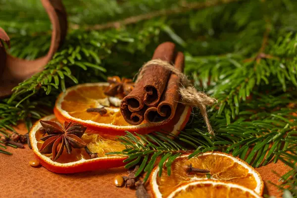 Kurumuş portakal parçaları, tarçın çubukları, çam kozalakları, yıldız anasonu ve Noel ağacı dallarıyla Noel doğası düzenlemesi