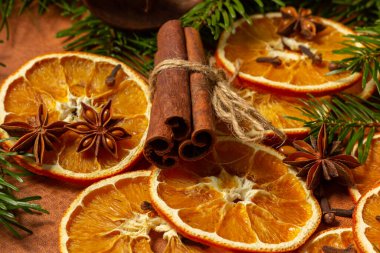 Kurumuş portakal parçaları, tarçın çubukları, çam kozalakları, yıldız anasonu ve Noel ağacı dallarıyla Noel doğası düzenlemesi