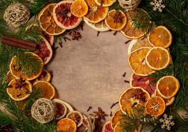 Kurumuş portakal parçaları, tarçın çubukları, çam kozalakları, yıldız anasonu ve Noel ağacı dallarıyla Noel doğası düzenlemesi