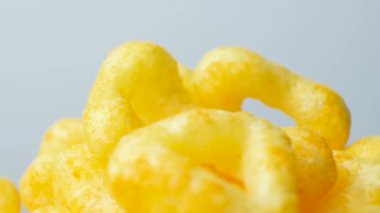 Baharatlı lezzetli mısır cipsleri beyaz arka planda daireler çiziyor.