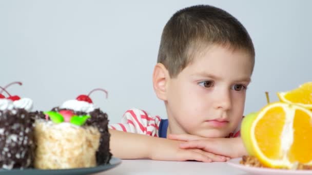 Mały Chłopiec Wybiera Jeść Ciasto Czy Owoce — Wideo stockowe