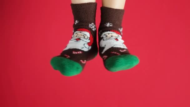 Frauenfüße Weihnachtssocken Mit Weihnachtsmann Auf Rotem Hintergrund Beine Tanzen — Stockvideo