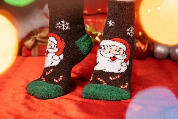 stock image Women's feet in warm Christmas socks with Santa Claus close-up.