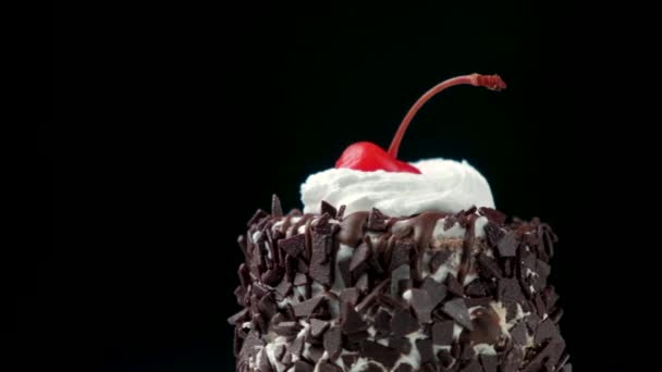 带有奶油和釉面樱桃的美味巧克力蛋糕在黑色背景上旋转 — 图库视频影像