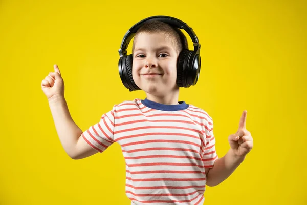 Szczęśliwy Chłopiec Słuchawkach Koszulce Wskazuje Palcami Żółtym Tle — Zdjęcie stockowe