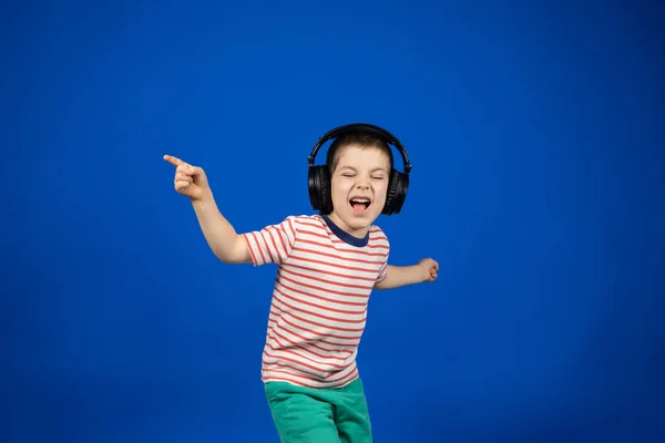 Szczęśliwy Inteligentny Letni Chłopiec Dużych Czarnych Słuchawkach Wskazuje Palce Boki — Zdjęcie stockowe