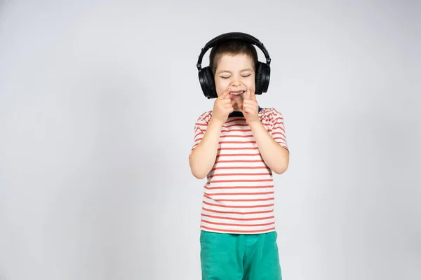Cute Letni Chłopiec Duże Czarne Słuchawki Śmieje Się Wskazuje Palcami — Zdjęcie stockowe