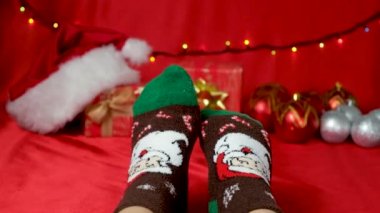 Kırmızı arka planda Noel Baba ile sıcak Noel çorapları içinde, tatili bekliyor..