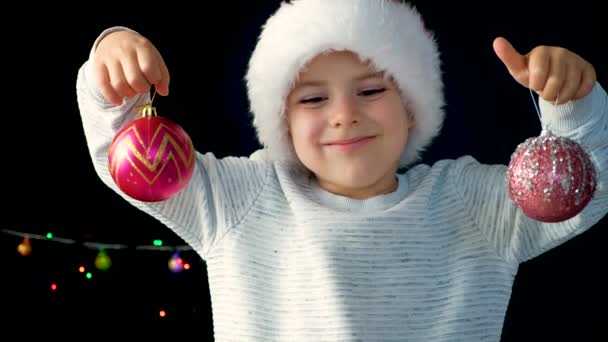 Счастливый Летний Мальчик Шляпе Санты Веселится Красными Рождественскими Шарами — стоковое видео